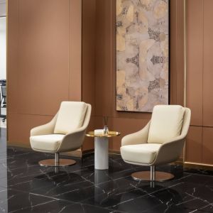 Neutral tone hand-painted wall art paired with modern lounge chairs in hotel lobby