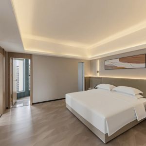zhuhai meichen hotel guest room interior with minimalist abstract wall painting above bed