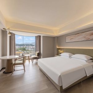 zhuhai meichen hotel guest room interior with minimalist abstract wall painting above bed